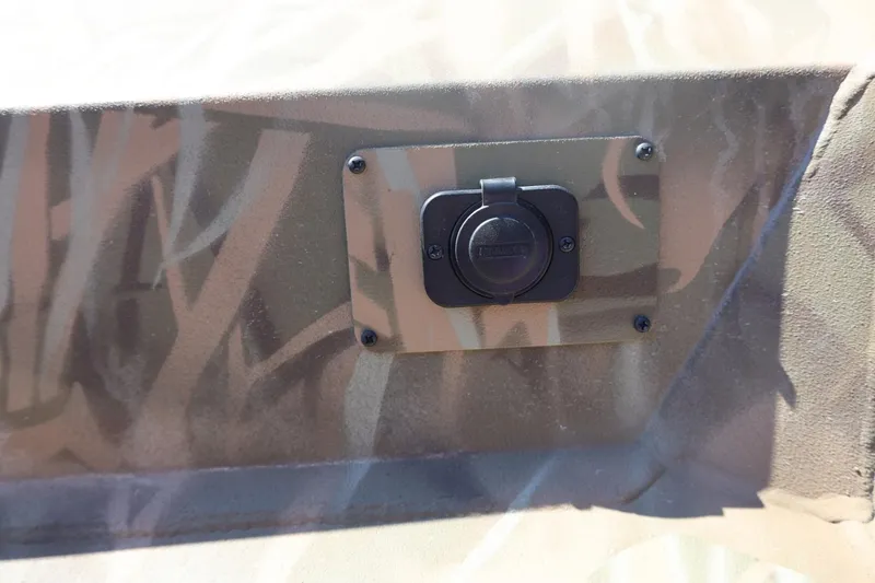 Slide: The Image of Camouflage-patterned Lowe Roughneck RX2070 SC 2026 boat detail with a mounted power outlet. - 15