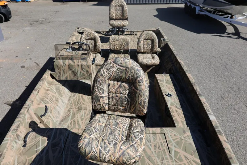 Slide: The Image of 2026 Lowe Roughneck RX2070 SC boat with camouflage seating, parked on pavement. - 17