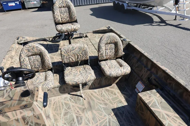 Slide: The Image of 2026 Lowe Roughneck RX2070 SC boat with camo seats and steering wheel, parked on pavement. - 19