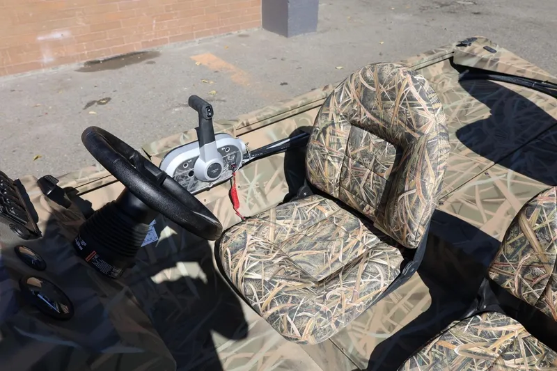 Slide: The Image of 2026 Lowe Roughneck RX2070 SC boat interior with camo seats and steering wheel. - 20