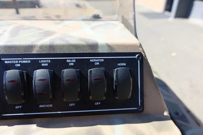 Slide: The Image of Control panel of 2026 Lowe Roughneck RX2070 SC boat with switches for power, lights, bilge, aerator, horn. - 22