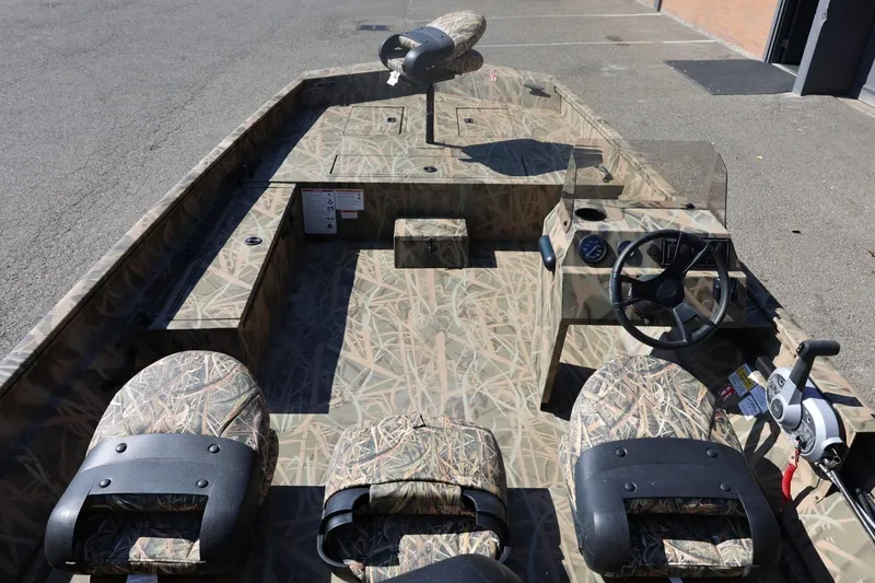 Slide: The Image of 2026 Lowe Roughneck RX2070 SC boat interior with camouflage seats and steering console. - 8