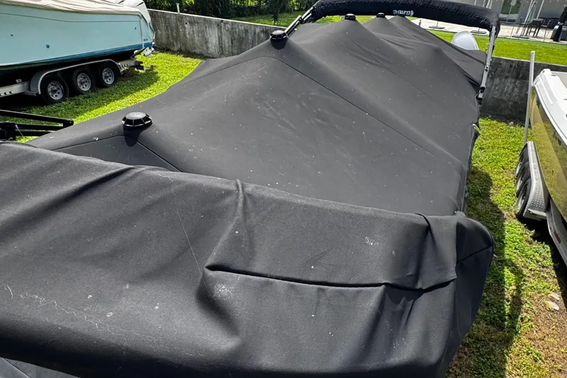 Slide: The Image of 2023 Tahoe Pontoon Cascade Platinum Quad Lounger covered, parked on grass. - 12