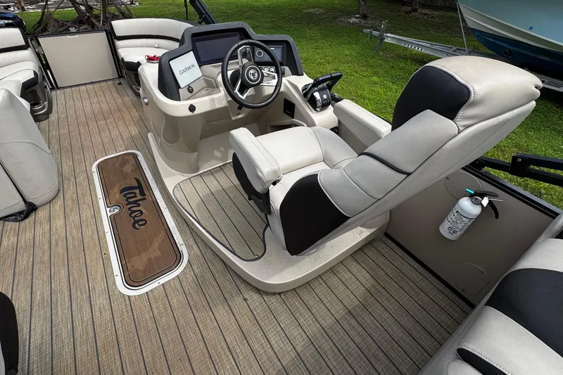 Slide: The Image of 2023 Tahoe Pontoon Cascade Platinum Quad Lounger interior with steering console and seating. - 24