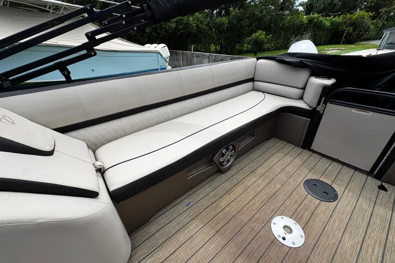 Slide: The Image of 2023 Tahoe Pontoon Cascade Platinum Quad Lounger interior with luxurious seating and wood-style flooring. - 29