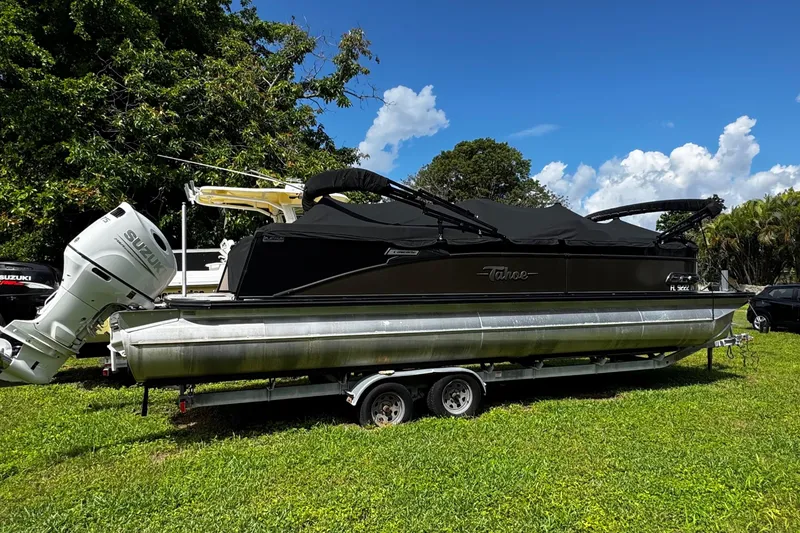 Slide: The Image of 2023 Tahoe Pontoon Cascade Platinum Quad Lounger on trailer, parked on grass. - 3
