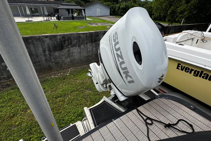 Slide: The Image of 2023 Tahoe Pontoon Cascade Platinum with Suzuki outboard motor, docked near a grassy area. - 33