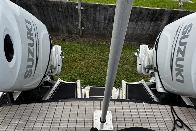 Slide: The Image of 2023 Tahoe Pontoon Cascade Platinum with dual Suzuki outboard motors, docked on grass. - 34