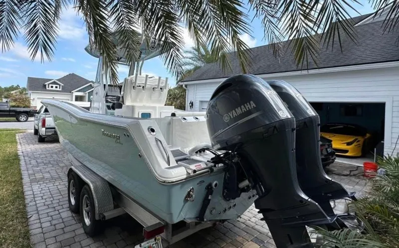 Slide: The Image of 2022 Tidewater 272 CC Adventure boat with Yamaha engines on a trailer in a driveway. - 14