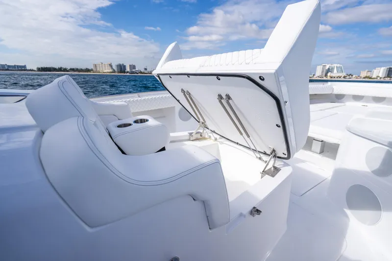 Slide: The Image of 2026 HCB 53 Suenos RXV boat interior with open storage compartment, white seating, and ocean view. - 13
