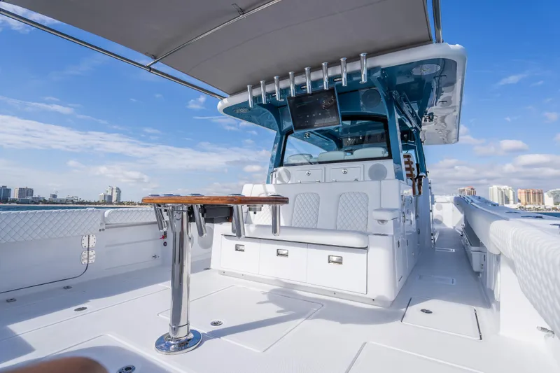 Slide: The Image of 2026 HCB 53 Suenos RXV luxury boat interior with seating and table, under a clear blue sky. - 27