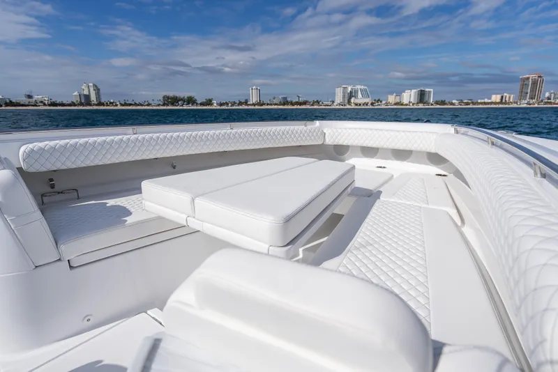 Slide: The Image of Luxurious seating on 2026 HCB 53 Suenos RXV boat with city skyline backdrop. - 9