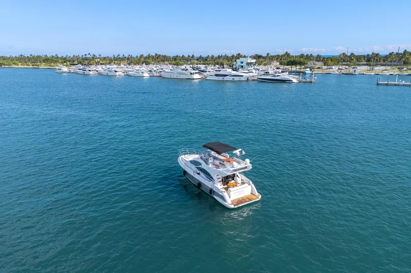 Slide: The Image of 2013 Azimut 45 Flybridge yacht cruising near a marina with multiple boats. - 11