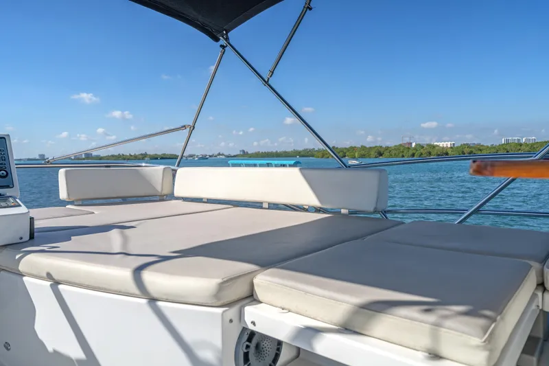 Slide: The Image of 2013 Azimut 45 Flybridge yacht deck with cushioned seating, overlooking serene waters. - 16