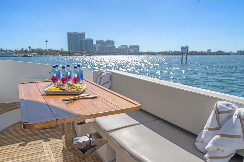 Slide: The Image of Luxurious 2013 Azimut 45 Flybridge yacht with dining setup, ocean view, and city skyline. - 23