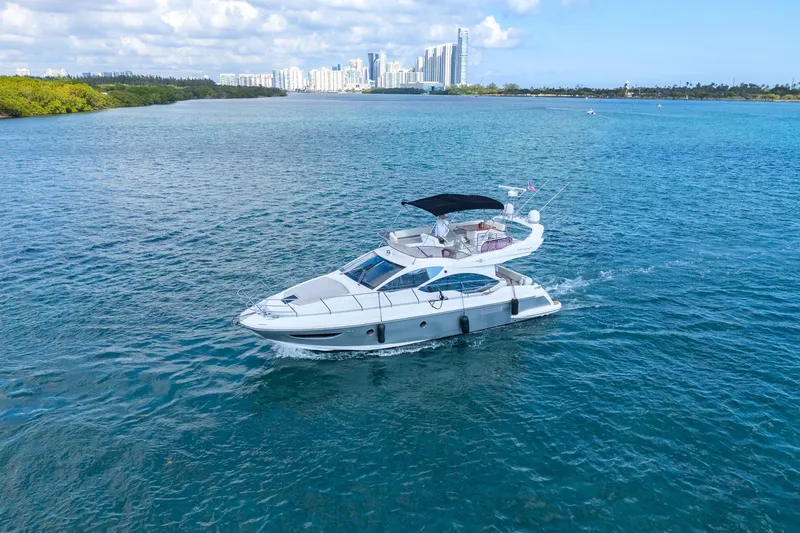 Slide: The Image of 2013 Azimut 45 Flybridge yacht cruising on blue water near city skyline. - 4