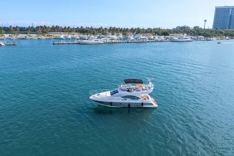 Slide: The Image of Azimut 45 Flybridge yacht from 2013 on calm blue waters near a marina. - 7