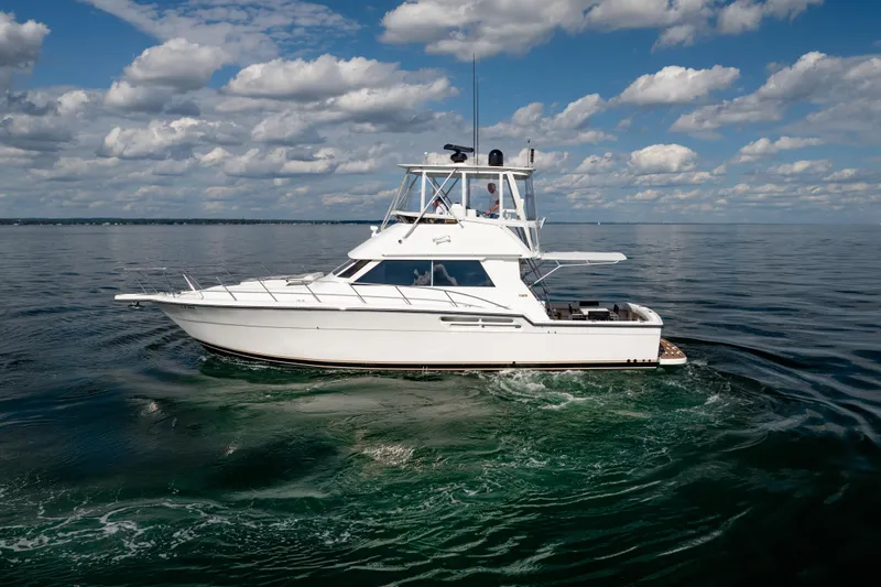 Slide: The Image of 2000 Tiara Yachts 4300 Convertible cruising on calm waters under a cloudy sky. - 10