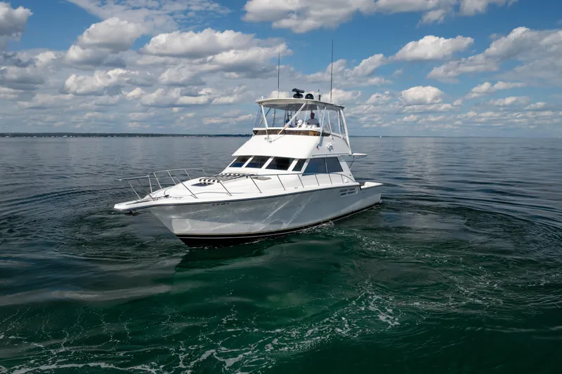 Slide: The Image of 2000 Tiara Yachts 4300 Convertible cruising on calm waters under a blue sky. - 13