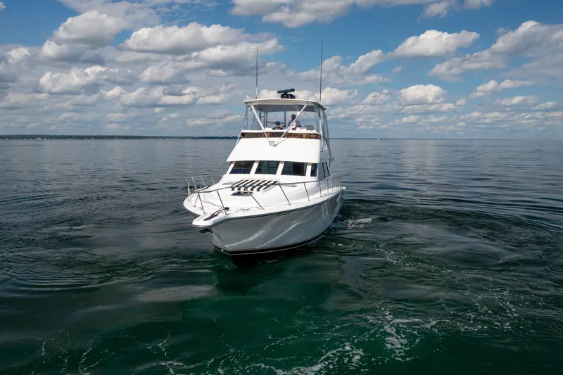 Slide: The Image of 2000 Tiara Yachts 4300 Convertible cruising on calm waters under a cloudy sky. - 14