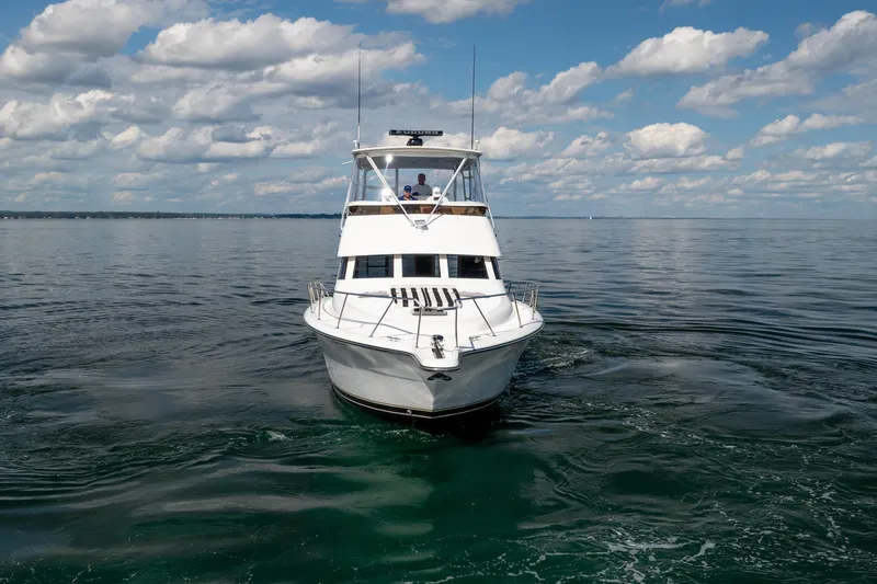 Slide: The Image of 2000 Tiara Yachts 4300 Convertible cruising on calm waters under a cloudy sky. - 15