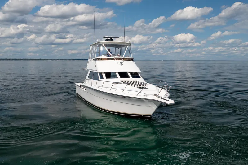 Slide: The Image of 2000 Tiara Yachts 4300 Convertible cruising on calm waters under a partly cloudy sky. - 16