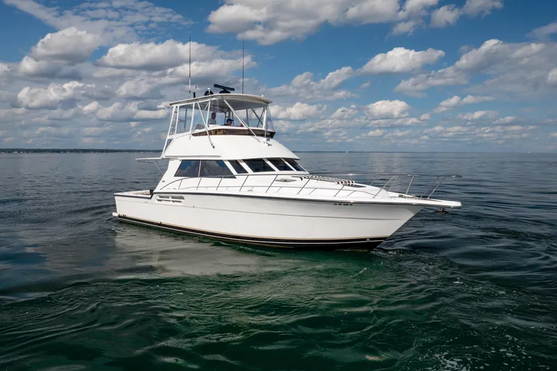 Slide: The Image of 2000 Tiara Yachts 4300 Convertible cruising on calm waters under a blue sky. - 17