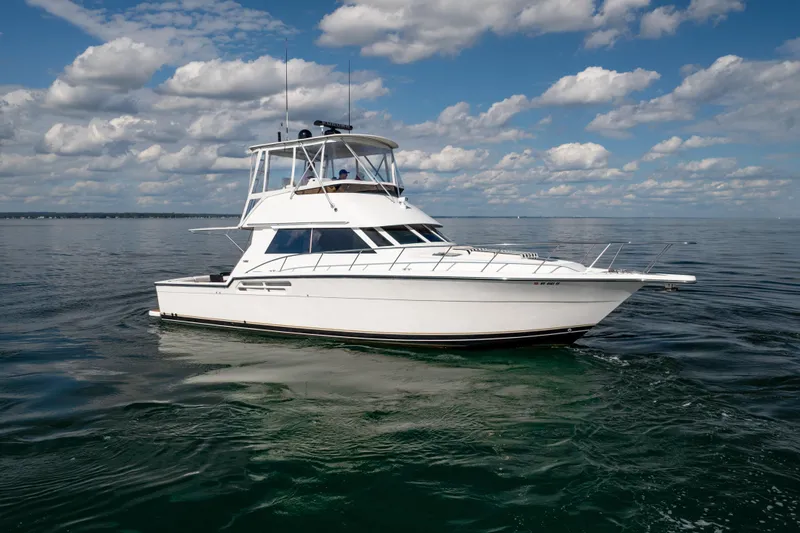 Slide: The Image of 2000 Tiara Yachts 4300 Convertible cruising on calm waters under a cloudy sky. - 18