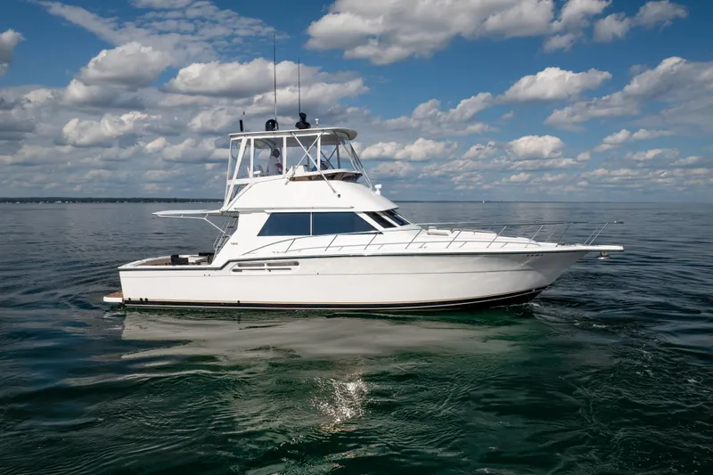 Slide: The Image of 2000 Tiara Yachts 4300 Convertible on calm water under a partly cloudy sky. - 19