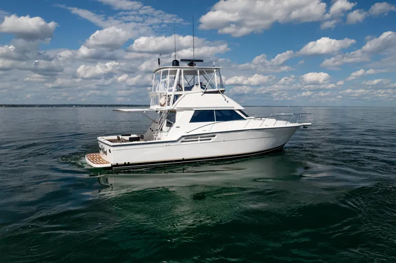 Slide: The Image of 2000 Tiara Yachts 4300 Convertible on calm water under a partly cloudy sky. - 21