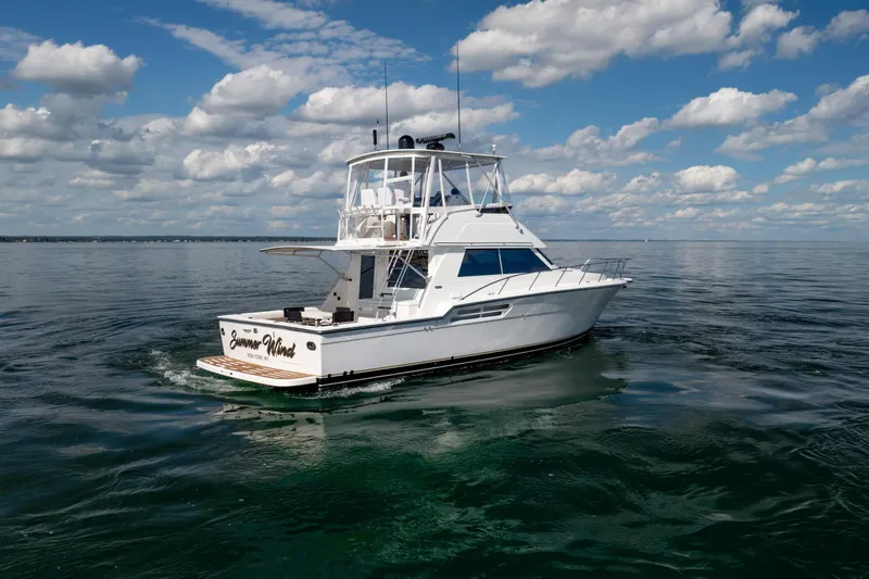 Slide: The Image of 2000 Tiara Yachts 4300 Convertible cruising on calm waters under a partly cloudy sky. - 22