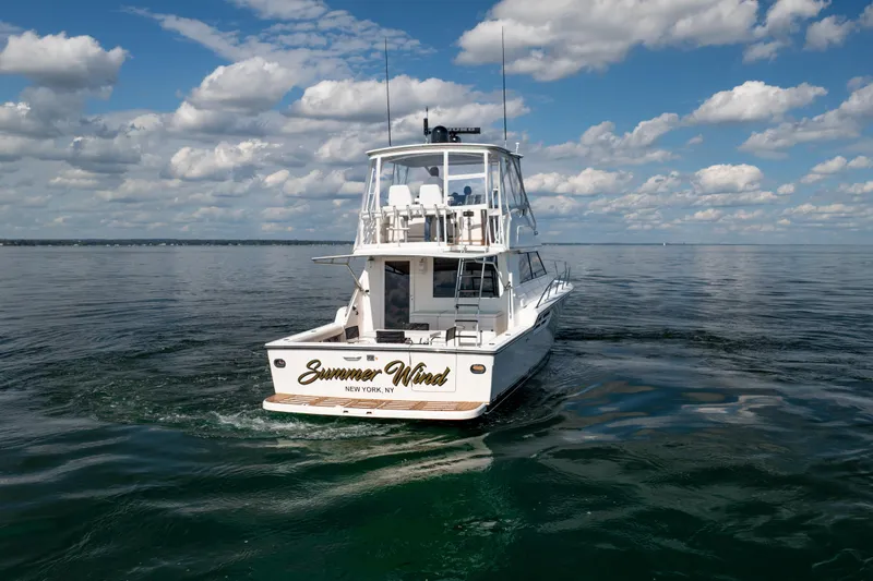 Slide: The Image of 2000 Tiara Yachts 4300 Convertible on calm water under a partly cloudy sky. - 24