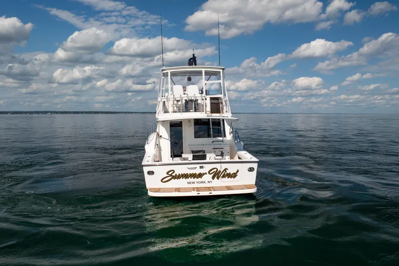 Slide: The Image of 2000 Tiara Yachts 4300 Convertible on calm water under a cloudy sky. - 25