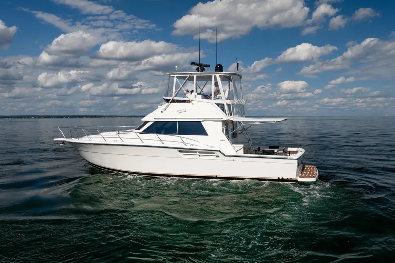 Slide: The Image of 2000 Tiara Yachts 4300 Convertible cruising on calm waters under a partly cloudy sky. - 29