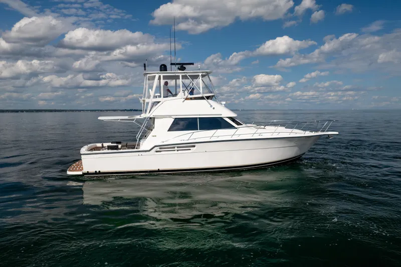 Slide: The Image of 2000 Tiara Yachts 4300 Convertible cruising on calm waters under a partly cloudy sky. - 36