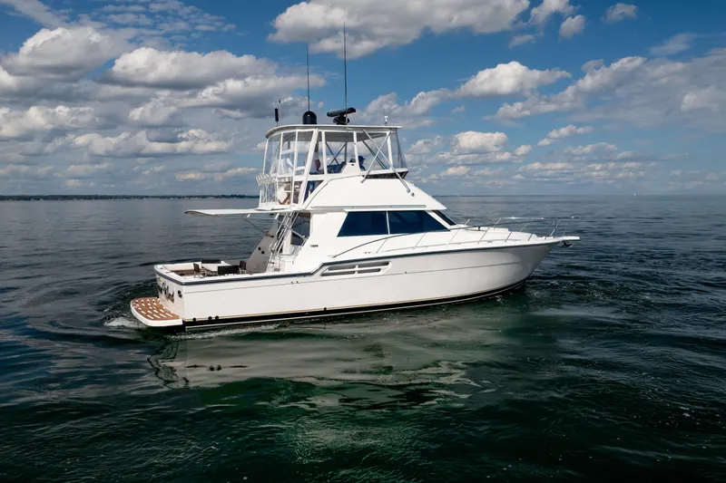 Slide: The Image of 2000 Tiara Yachts 4300 Convertible cruising on calm waters under a blue sky. - 37