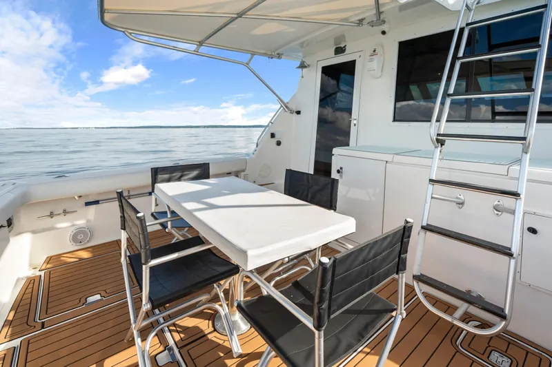 Slide: The Image of Outdoor seating area on 2000 Tiara Yachts 4300 Convertible, featuring table and chairs. - 42