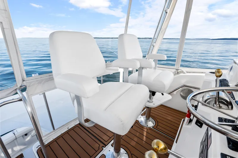 Slide: The Image of Helm of 2000 Tiara Yachts 4300 Convertible with white captain chairs and ocean view. - 44