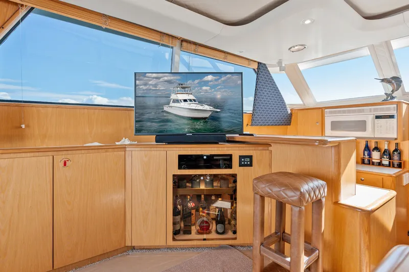 Slide: The Image of Interior of 2000 Tiara Yachts 4300 Convertible with TV, bar, and seating. - 51