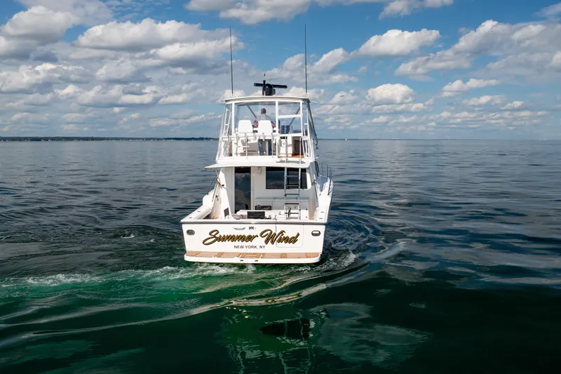 Slide: The Image of 2000 Tiara Yachts 4300 Convertible cruising on calm waters under a blue sky. - 6