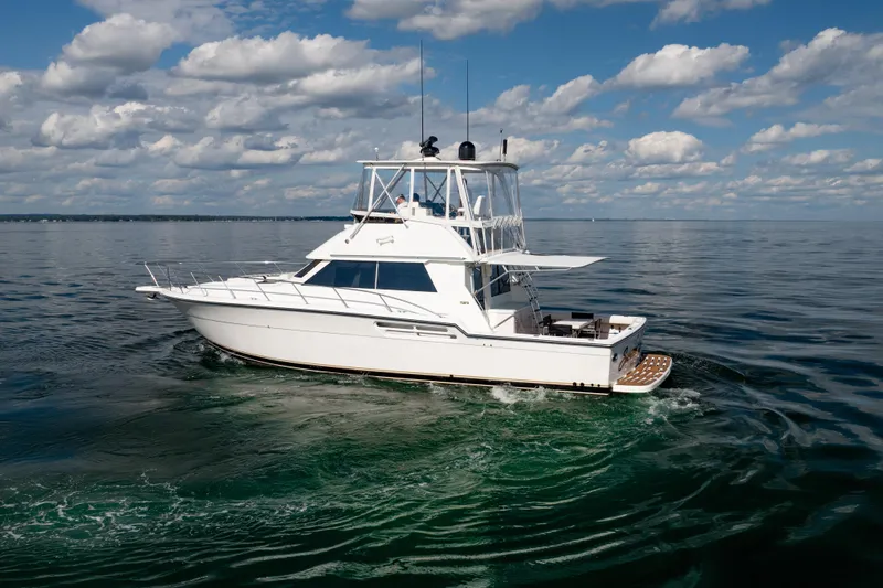 Slide: The Image of 2000 Tiara Yachts 4300 Convertible cruising on calm ocean waters under a partly cloudy sky. - 9