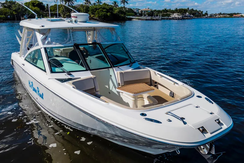 Slide: The Image of 2019 Boston Whaler 320 Vantage boat on calm water, featuring sleek design and spacious seating. - 13