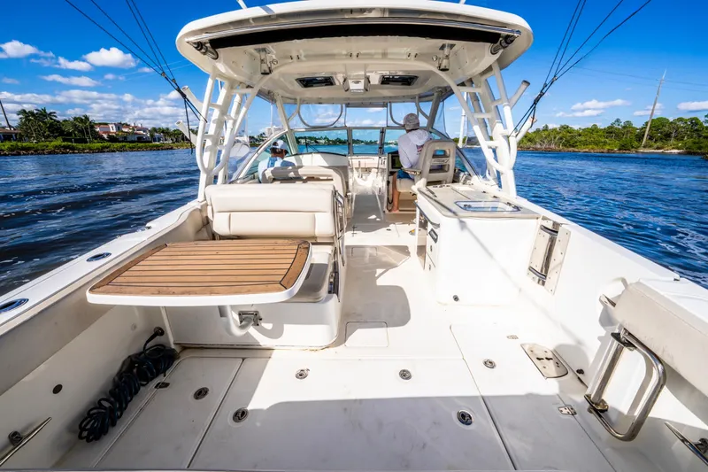 Slide: The Image of 2019 Boston Whaler 320 Vantage boat interior with seating and table on a sunny day. - 21