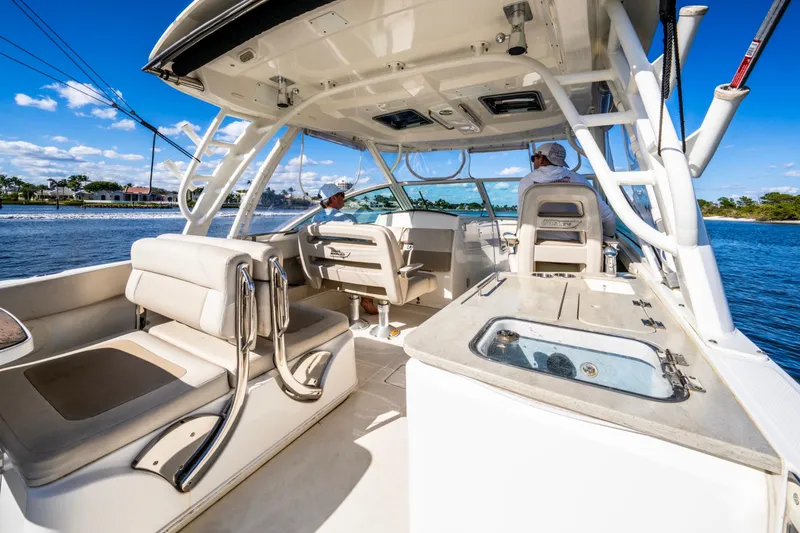 Slide: The Image of 2019 Boston Whaler 320 Vantage boat interior with seating and helm, cruising on a sunny day. - 23