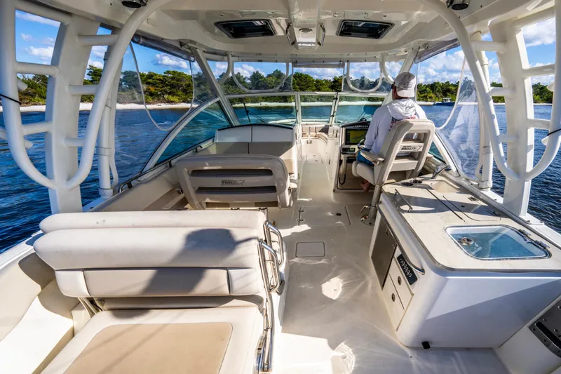 Slide: The Image of 2019 Boston Whaler 320 Vantage interior, featuring seating and helm, cruising on a sunny day. - 24