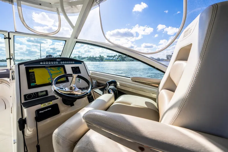 Slide: The Image of 2019 Boston Whaler 320 Vantage helm with navigation system, steering wheel, and luxurious seating. - 26