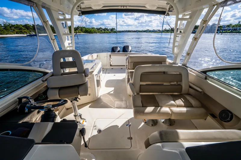 Slide: The Image of 2019 Boston Whaler 320 Vantage boat interior with seating and steering, overlooking calm waters. - 27