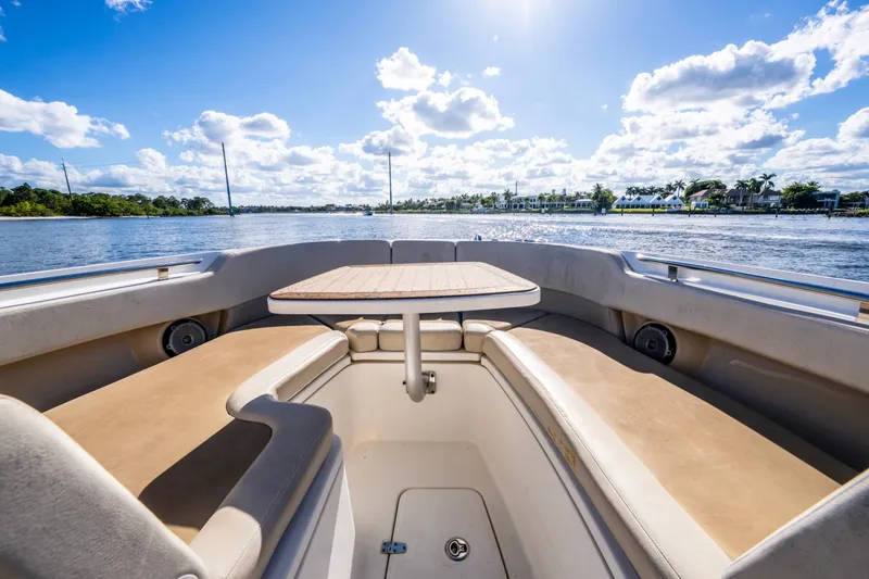 Slide: The Image of 2019 Boston Whaler 320 Vantage boat interior with seating and table, under sunny skies. - 28