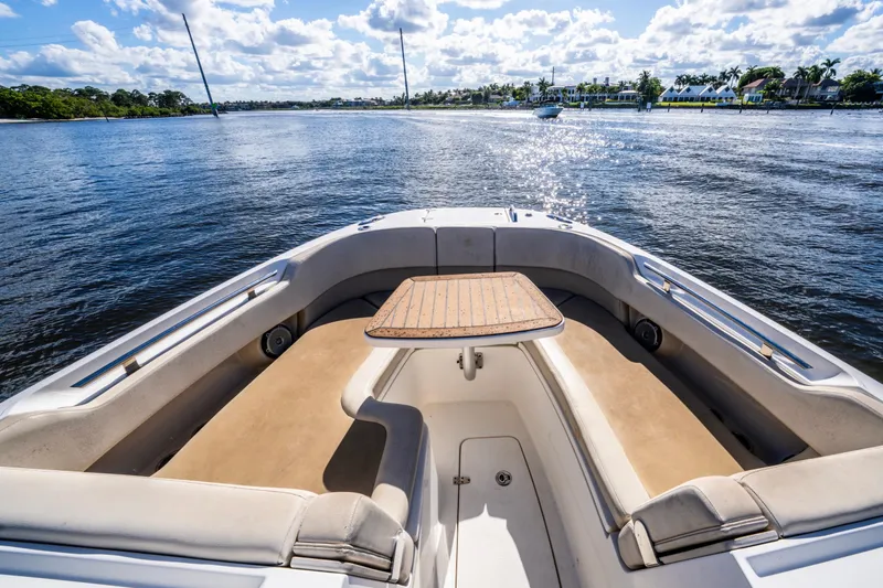 Slide: The Image of 2019 Boston Whaler 320 Vantage boat interior with seating and table on a sunny day. - 29