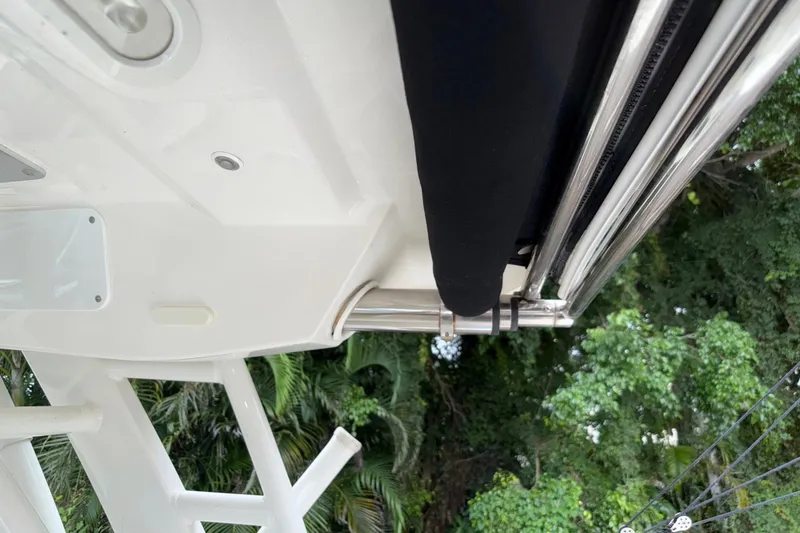 Slide: The Image of 2019 Boston Whaler 320 Vantage boat detail with lush greenery in the background. - 32